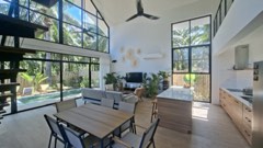 Séjour lumineux avec vue sur la piscine et les palmiers